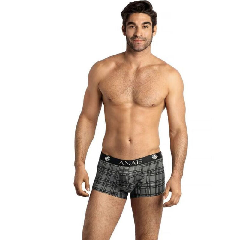 A standing male model wearing grey checked boxer briefs in a neutral studio photograph.